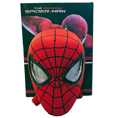 A red and black Spider-Man mask displayed in front of its retail box, which features 'The Amazing Spider-Man' branding and an illustration of Spider-Man.